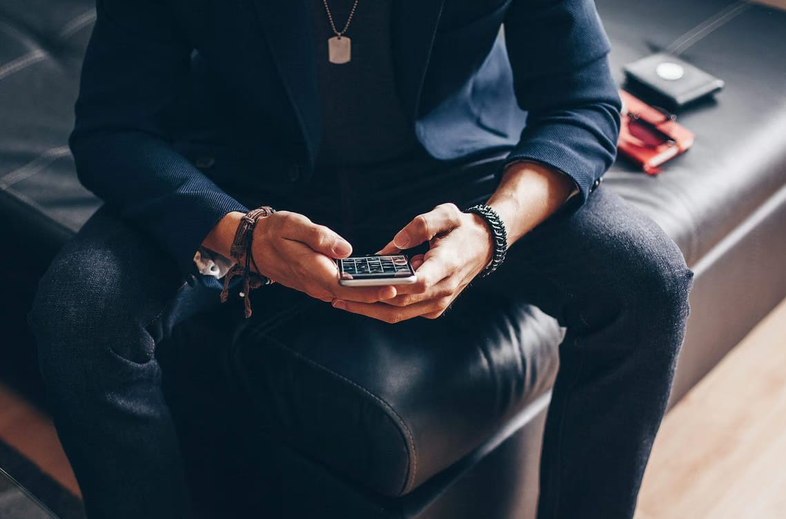 a man using his phone to share content in social media pages.