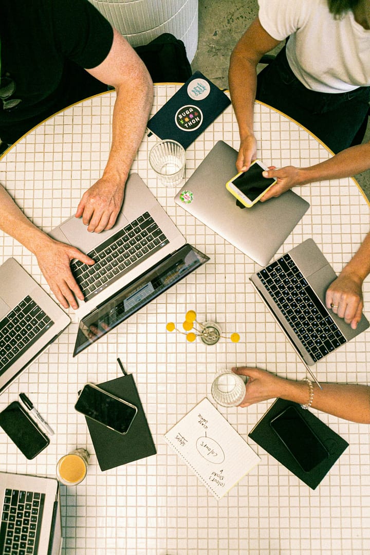 A group working on a project at a table with a laptop